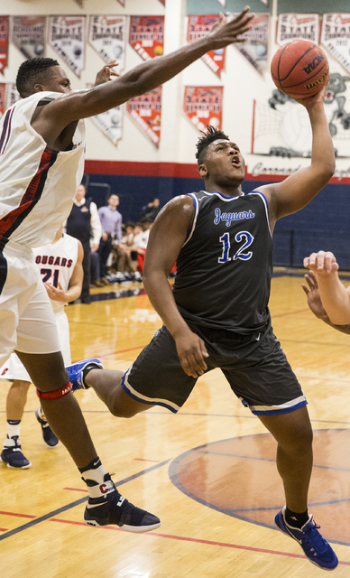 Desert Pines’ Jalen Graves (12) slices to the rim past Coronado’s Will Weems (11 ...