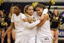 Essence Booker (center) and Kayla Harris share a hug during a game last season. (Ronda Churc ...