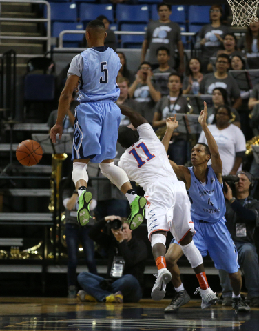 Bishop Gorman’s Obim Okeke gets fouled driving through Canyon Springs defenders Gerad ...