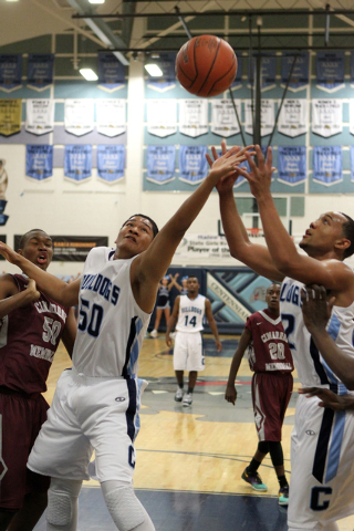 Centennial’s Eddie Davis (50) goes for a rebound between Cimarron-Memorial center Terr ...