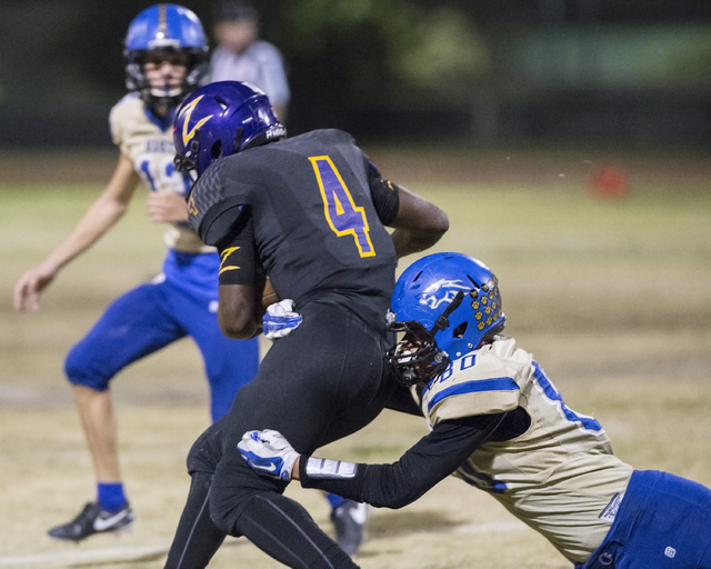 Durango running back Boogie Kamara (4) is wrapped up by Sierra Vista defender Chevy Eliu (80 ...