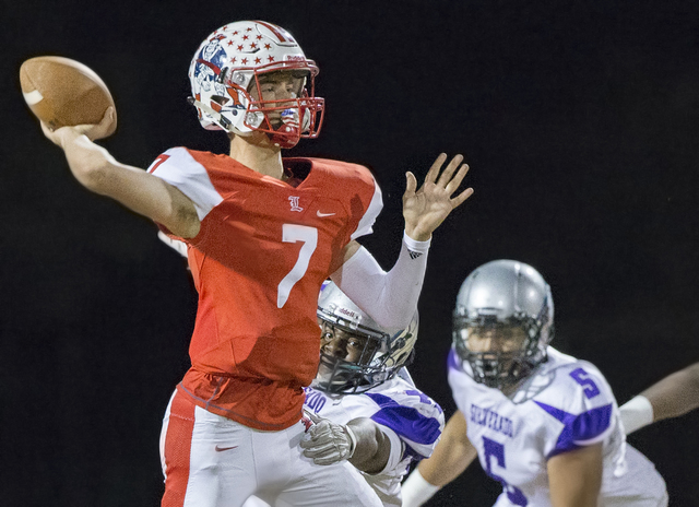 Liberty’s Kenyon Oblad (7) makes a pass with Silverado defenders on his back during th ...