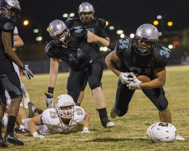 Silverado running back Keikiokalani Misipeka (34) avoids a loose helmut as he runs down the ...