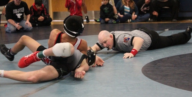 Referee Jimmy Guerino looks in just before Las Vegas freshman Antonio Saldate scores a pin o ...