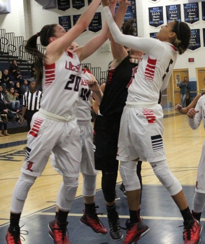 Liberty’s Jaelyn Royal, right, and teammate Kealy Brown contend for a rebound against Troy ...