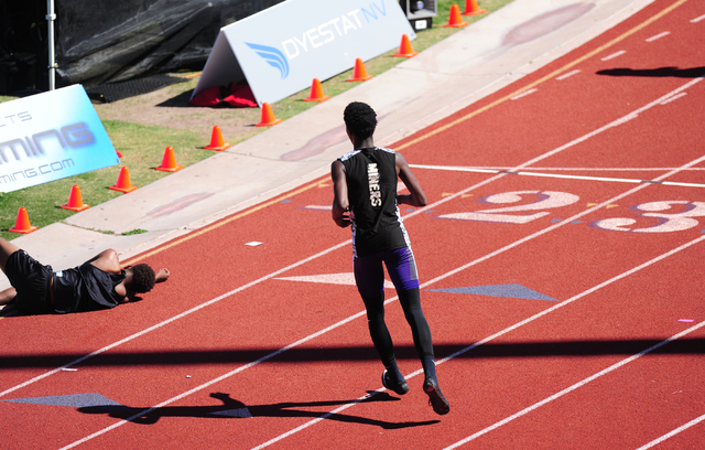 Sunrise Mountain runner Steven Walker, right, stops his race to help out Palo Verde runner C ...