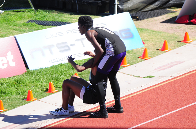 Sunrise Mountain runner Steven Walker, right, stops his race to help out Palo Verde runner C ...