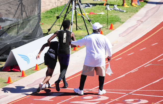 Sunrise Mountain runner Steven Walker, right, stops his race to help out Palo Verde runner C ...