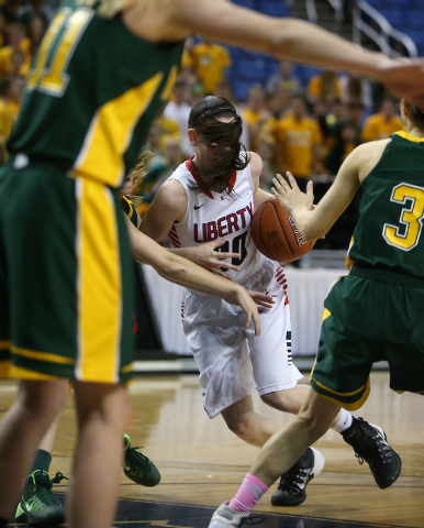 With her hair flying, Liberty’s Kealy Brown drives through a crowd of Bishop Manogue d ...