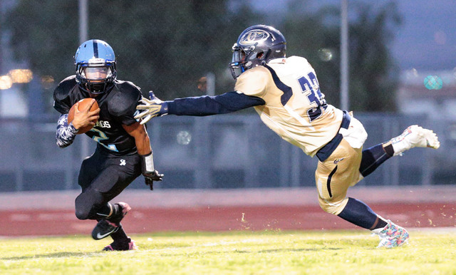 Cheyenne junior Clarence Rose (32) reaches out for Canyon Springs junior Diamante Burton (2) ...