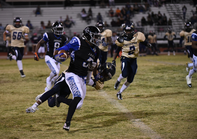 Desert Pines Eddie Heckard (5) runs down field against Cheyenne’s defense during their ...