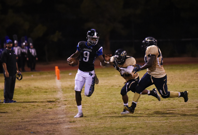 Desert Pines Randal Grimes (9) runs the ball against the Cheyenne defense during their footb ...