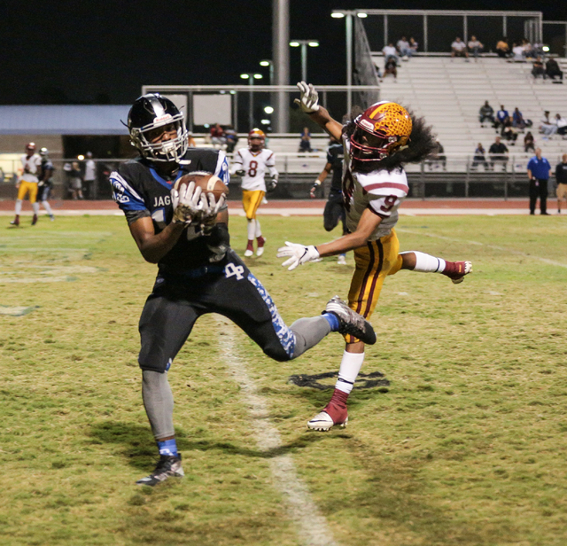 Desert Pines senior Jordan Simon (12) catches a ball in the end zone as Del Sol junior Barry ...