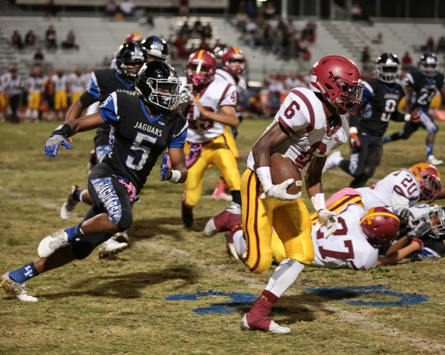 Desert Pines senior Eddie Heckard (5), left, chases down Del Sol sophomore Titan Williams (6 ...