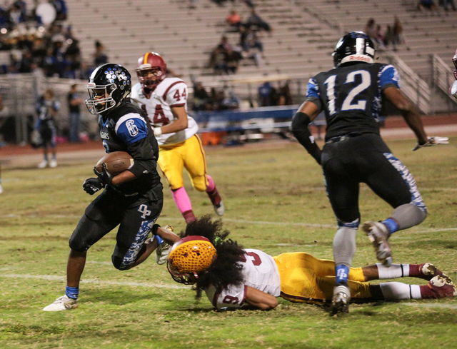 Desert Pines junior DeAundre Newsome (6) runs the ball while Del Sol junior Barry Williams ( ...