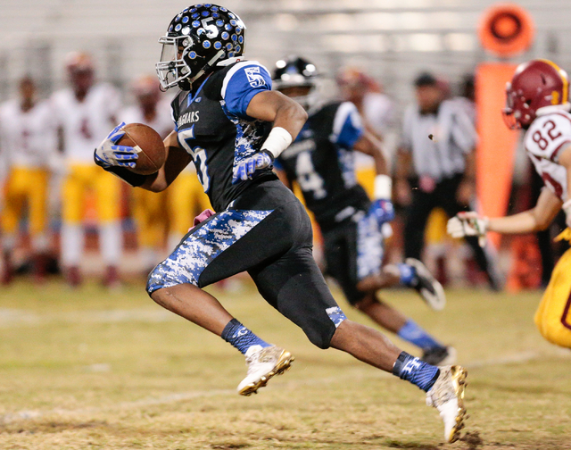 Desert Pines senior Eddie Heckard (5) runs the ball down the field while followed by Del Sol ...