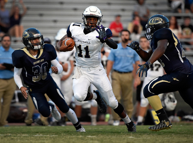 Foothill quarterback Jordan Wilson carries the ball against Cheyenne’s Joseph Kunicki ...