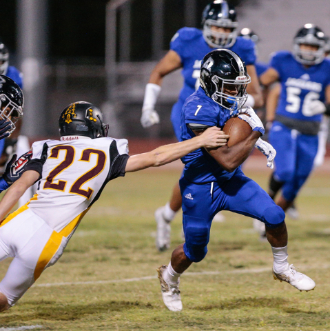 Pahrump Valley senior Drew Walker (22) reaches out for Desert Pines senior Isaiah Morris (7) ...