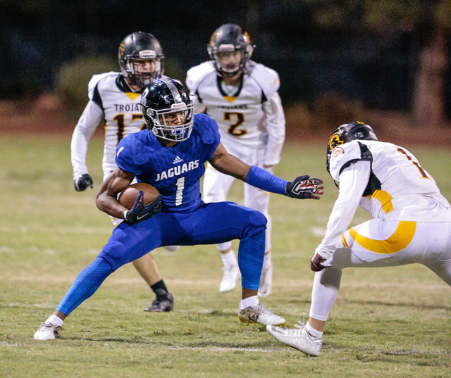 Desert Pines senior Tony Fields (1) attempts to maneuver around Pahrump Valley senior Daniel ...