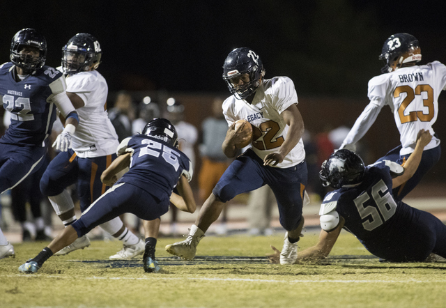 Samuel Turner (22) runs the ball through Shadow Ridge defenders during a Legacy High School ...