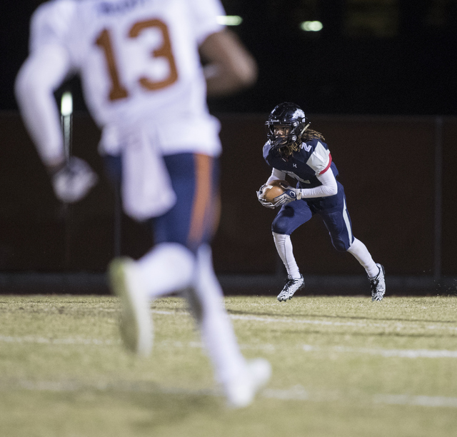 Elisha Young (2) advances the ball as Marcellous McCoy (13) runs towards him during a Legacy ...