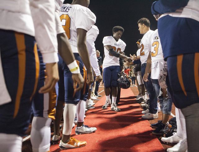 Christian Johnson is greeted by the other Legacy High School players before the Legacy High ...