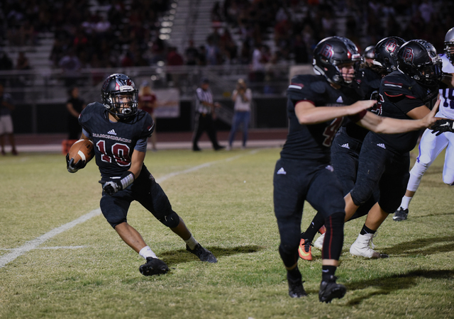 Desert Oasis Cordell Wooten (10) runs the ball against Silverado’s defense during thei ...