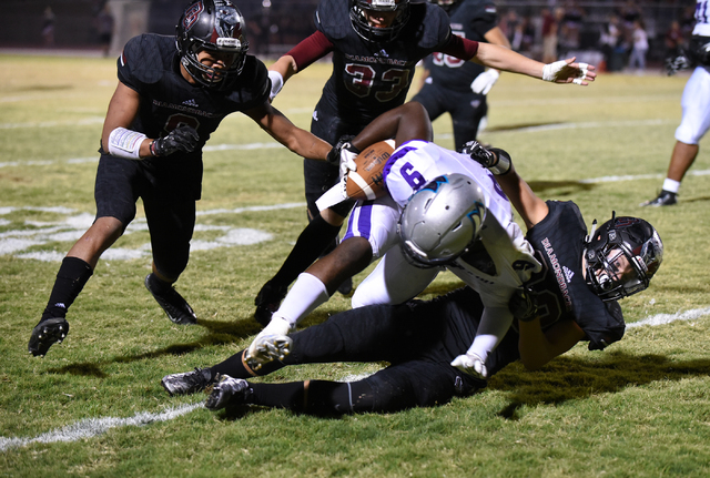 Silverado’s Nahzi Salih (9) is tackled by Desert Oasis Tyler Streicher (30) during the ...