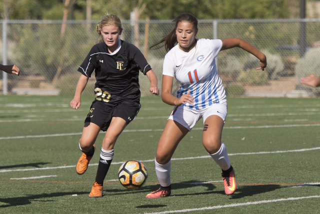 Bishop Gorman’s Kevyn Hillegass (11) and Faith Lutheran’s Amelia McManus (20) ru ...