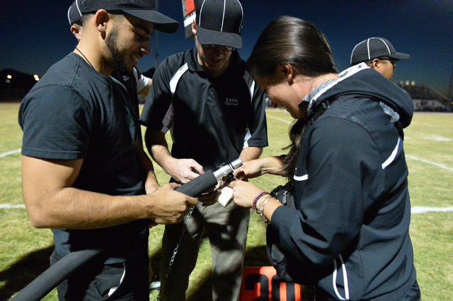 Officials call a trainer over to fix a broken chain on the stakes during the Foothill High S ...