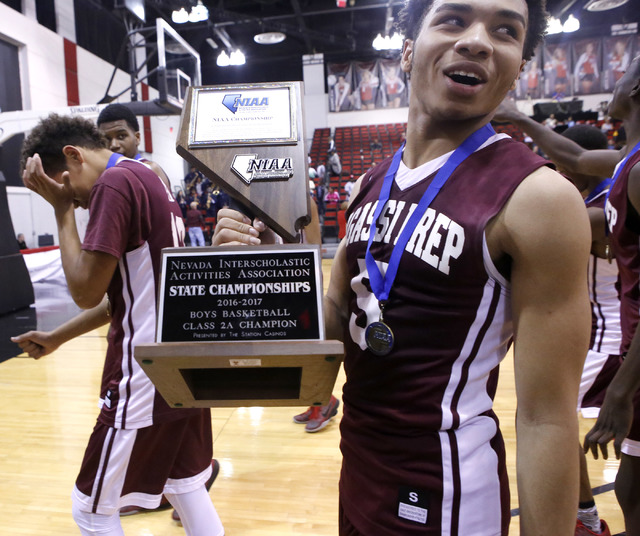 Agassi Prep’s Allen Merritt (5), right, holds the championship trophy after him and hi ...