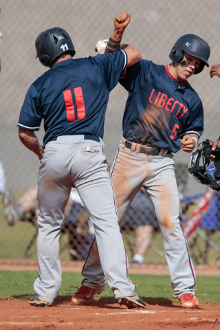 Liberty High School senior Preston Pavlica (11) left, celebrates at home plate with his team ...