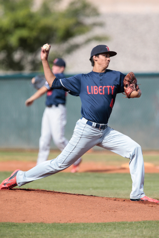 Liberty High School senior Bailey Daguio (4) stretches out for a pitch to the plate during a ...