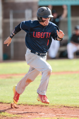 Liberty High School senior Lucas Bogues (1) hurries down the first base line after making a ...