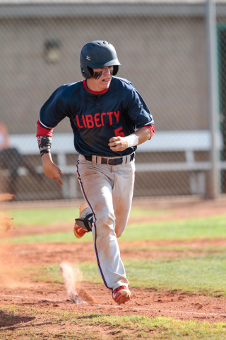 Liberty High School senior Nick Rush (5) runs down the first base line after making a hit du ...