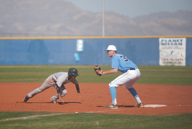 Rancho senior Bryce Harrell dives back to first base as Centennial senior Will Loucks awaits ...