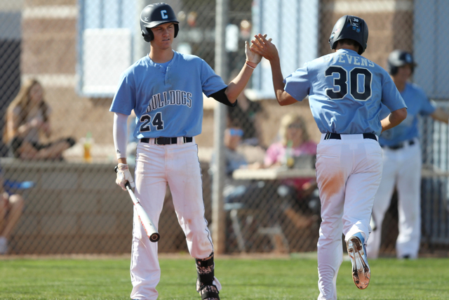 Centennial’s Jake Portaro (24) high fives Travis Stevens (30) after his sacrifice hit ...