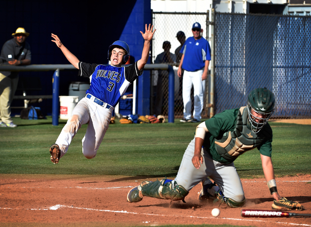 Basic’s Roger Riley (3) slides home as Green Valley catcher Ty Burger collects the bal ...