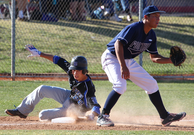 Basic’s Skyler Mahoney slides into third base for a triple as Foothill’s Tyler V ...