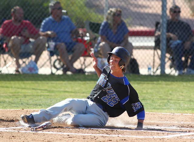 Basic’s Skyler Mahoney (22) slides into home during the first inning Thursday at Footh ...