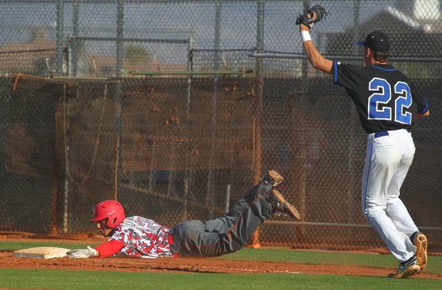 Arbor View’s Nick Quintana (12) slides into first base past Sierra Vista’s Nolan ...