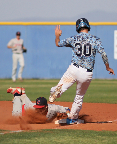 Coronado’s Nicco Festa, left, dives into first base to make the out as Coronado’ ...