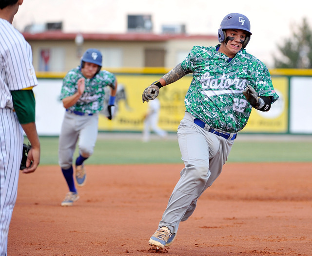 Green Valley’s Ty Burger (22) and Jarod Penniman run home after a triple by teammate C ...