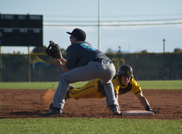 Bonanza’s Micah Higa (8) dives to tag first base as Silverado’s Samuel Pope (50) ...