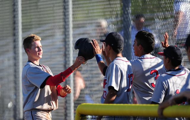 Liberty base runner Jacob Rogers high fives teammates after scoring a run against Coronado i ...