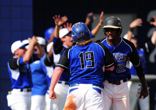 Basic base runner Jack Wold high fives J.J. Smith after scoring a run against Green Valley i ...