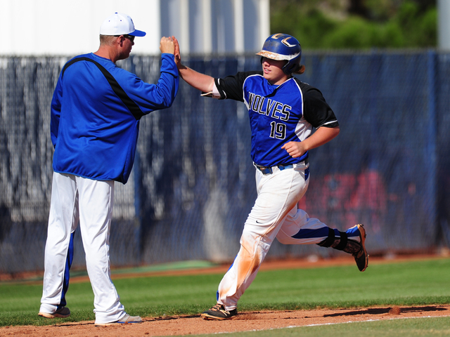 Basic batter Jack Wold high fives head coach Scott Baker after he hit a two run home run aga ...