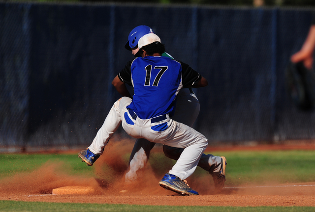 Basic shortstop Garrett Giles tags out Green Valley base runner Brandon Bayne at third base ...