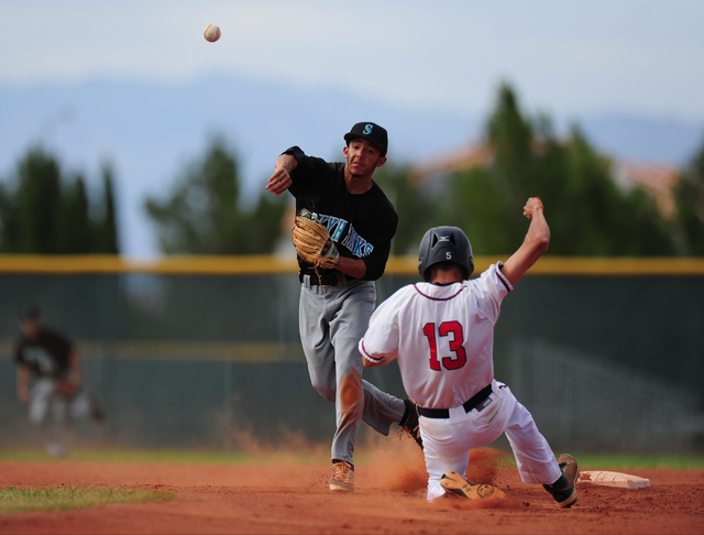 Silverado second baseman Alex Grafiada turns a double play while Liberty baserunner Anthony ...