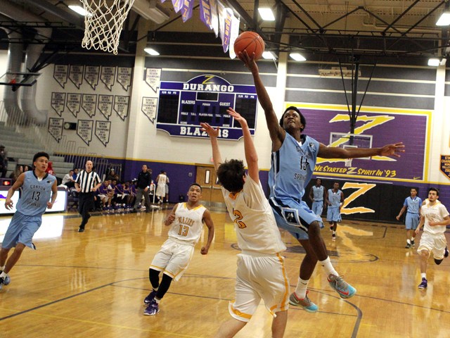 Canyon Springs guard Derrick Legardy (15) goes up for a shot over Durango guard Alex Tarkani ...